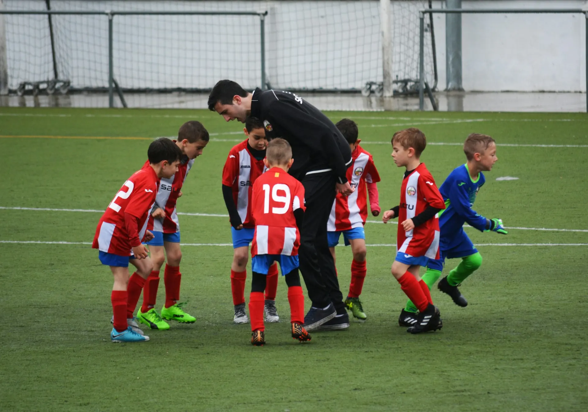 Jeugdtrainer bespreekt met jonge voetballers de wedstrijd